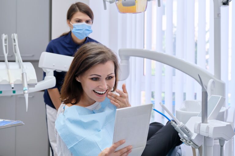 Happy Middle Aged Woman With Doctor Dentist Looking In Mirror At